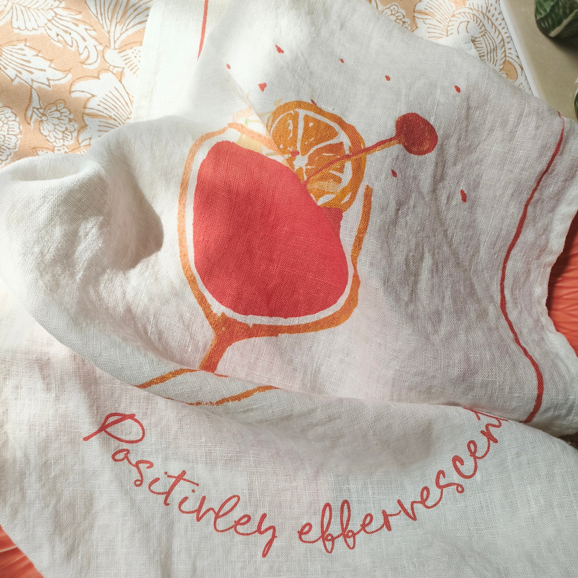 White towel with red cherry design and text on a patterned surface