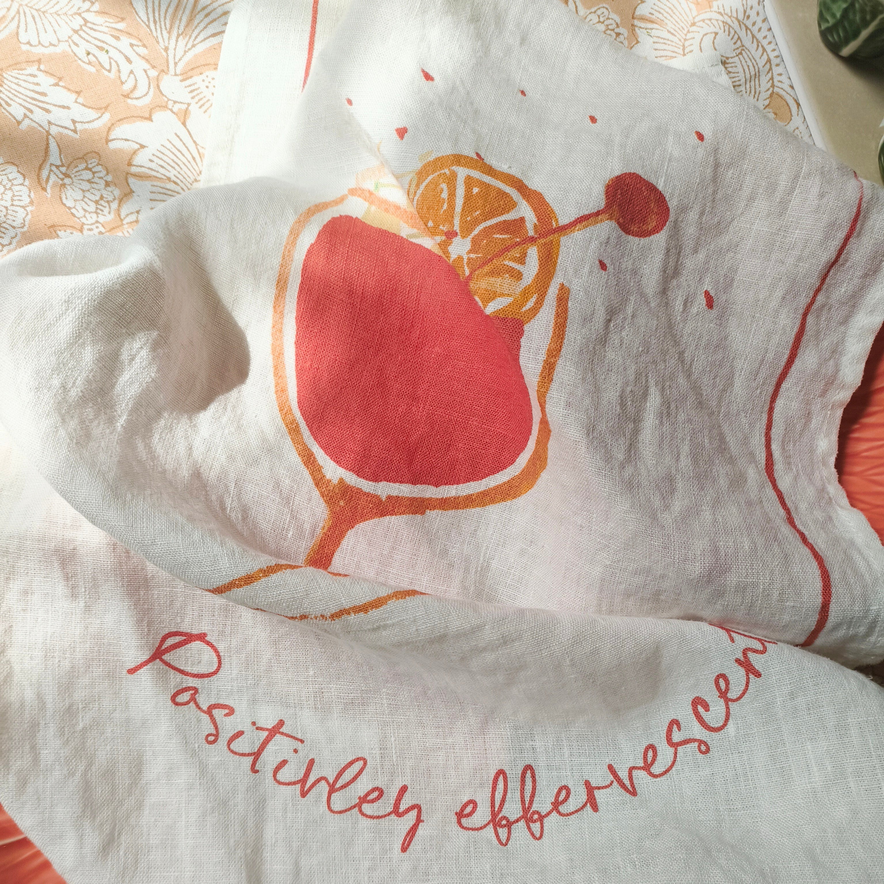 White towel with red cherry design and text on a patterned surface