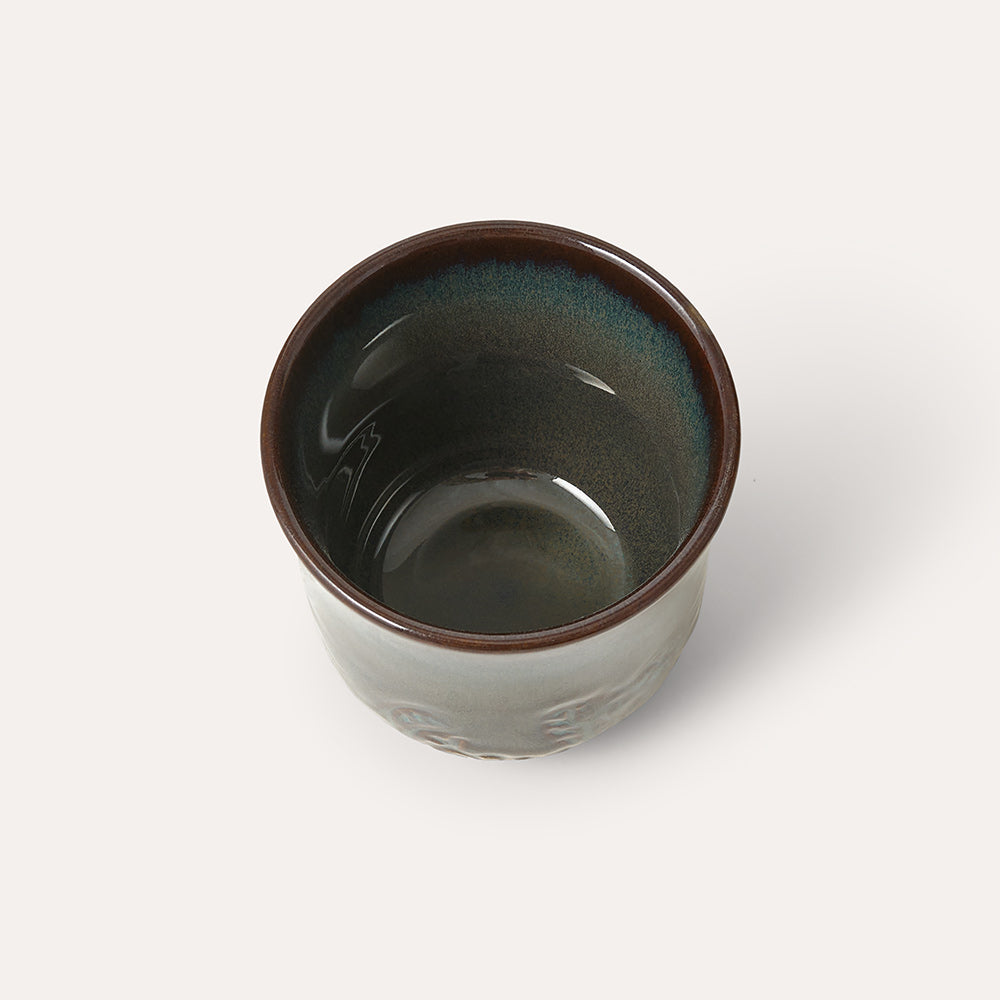 Ceramic cup with brown rim and interior on a white background