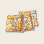 Patterned napkins with pink edges on. a beige background