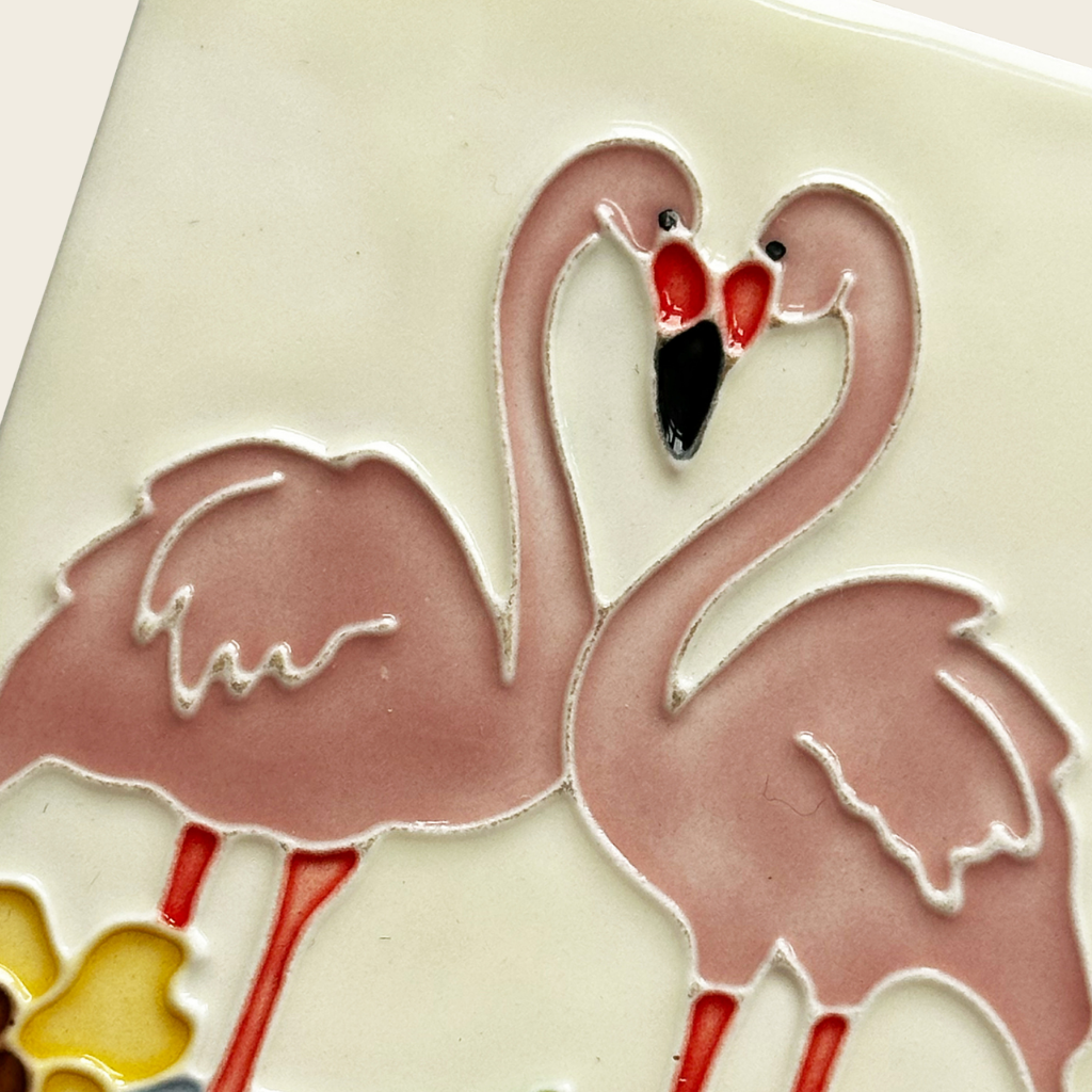 Decorative tile with pink flamingo design on a beige background