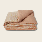 Folded quilt with floral pattern on a beige background