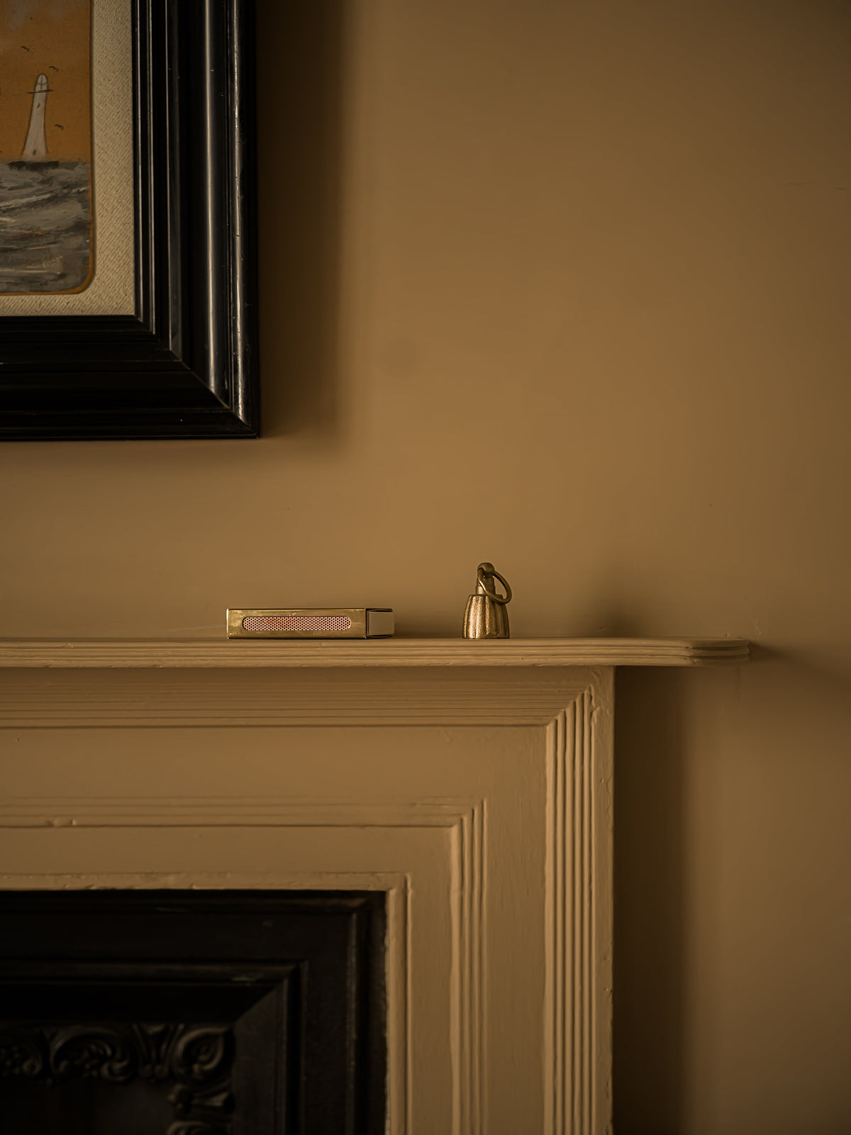 Fluted bell candle snuffer shown beside a candle