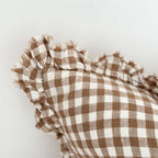 Brown and white checkered fabric with ruffled edges on a light gray background