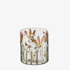 Clear glass candle holder with brown leaf design on a white background