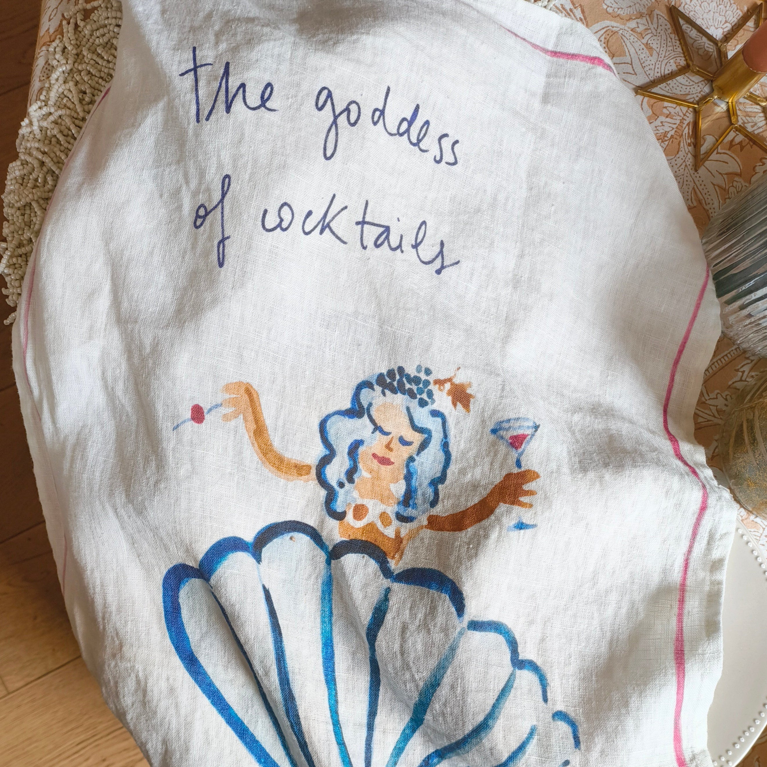 Decorative towel with a cartoon mermaid and text on a wooden surface