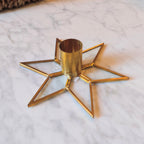 Gold star-shaped candle holder on a marble surface