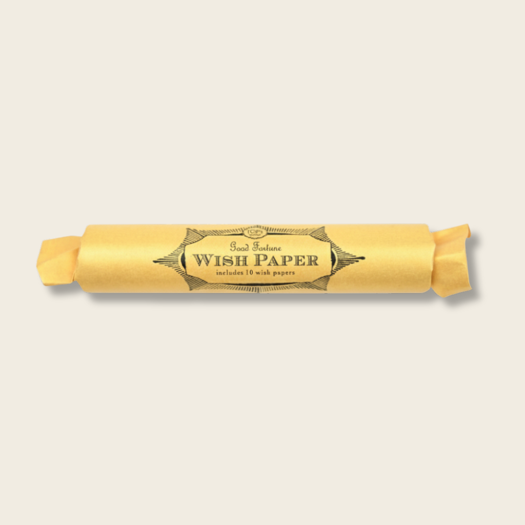 Roll of wish paper with a decorative label on a beige background