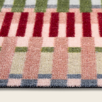 Close-up of a multicolored checkered rug with red, green, pink, and blue patterns.