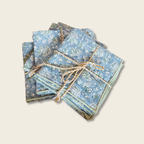 Stack of blue patterned napkins tied with twine on a wooden surface