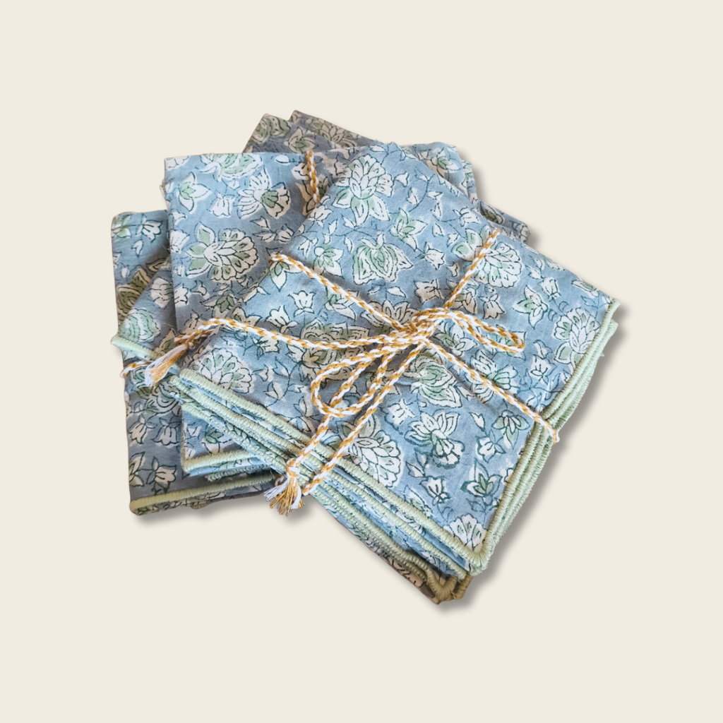 Stack of blue patterned napkins tied with twine on a wooden surface