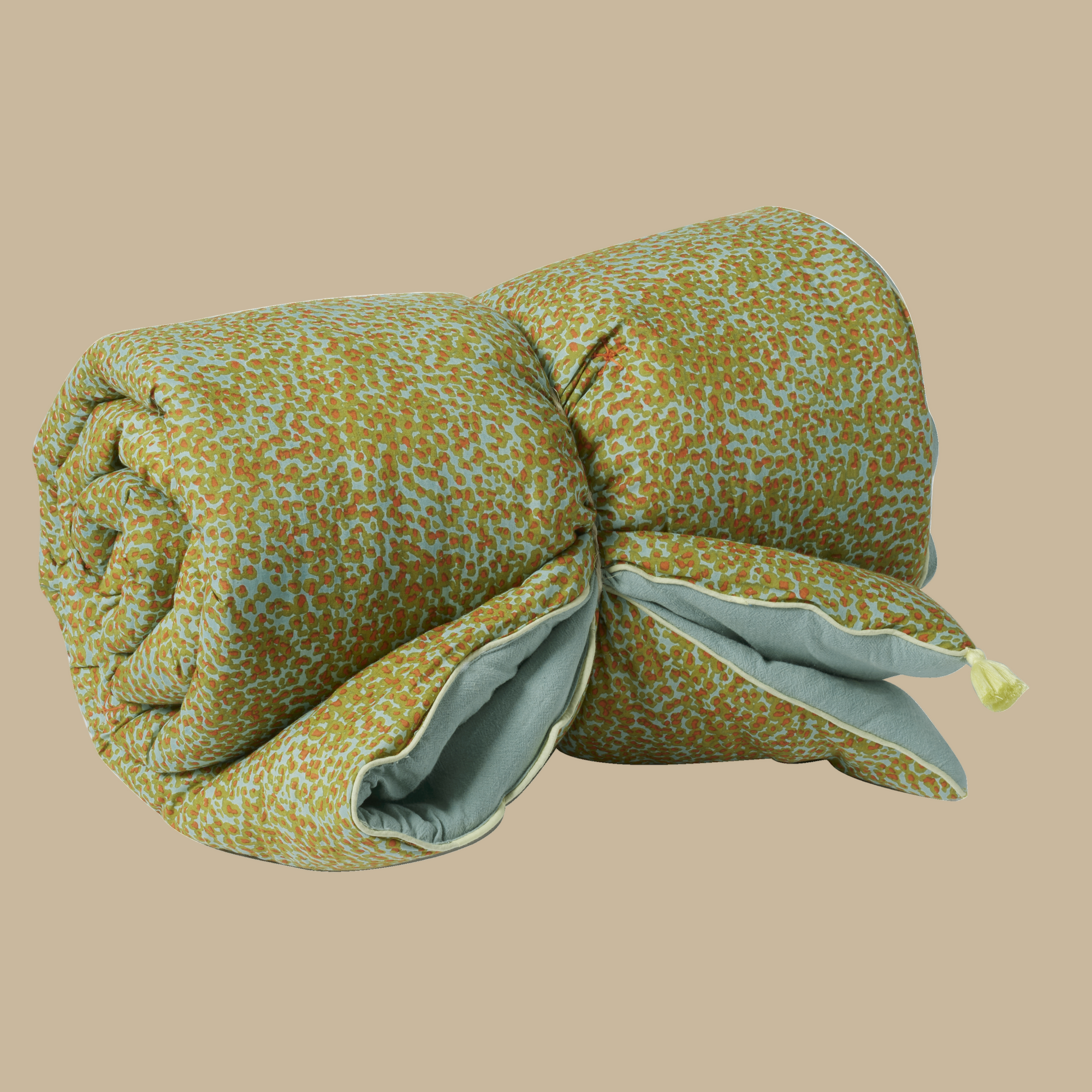 Folded floral-patterned blanket with a solid-colored back on a white background