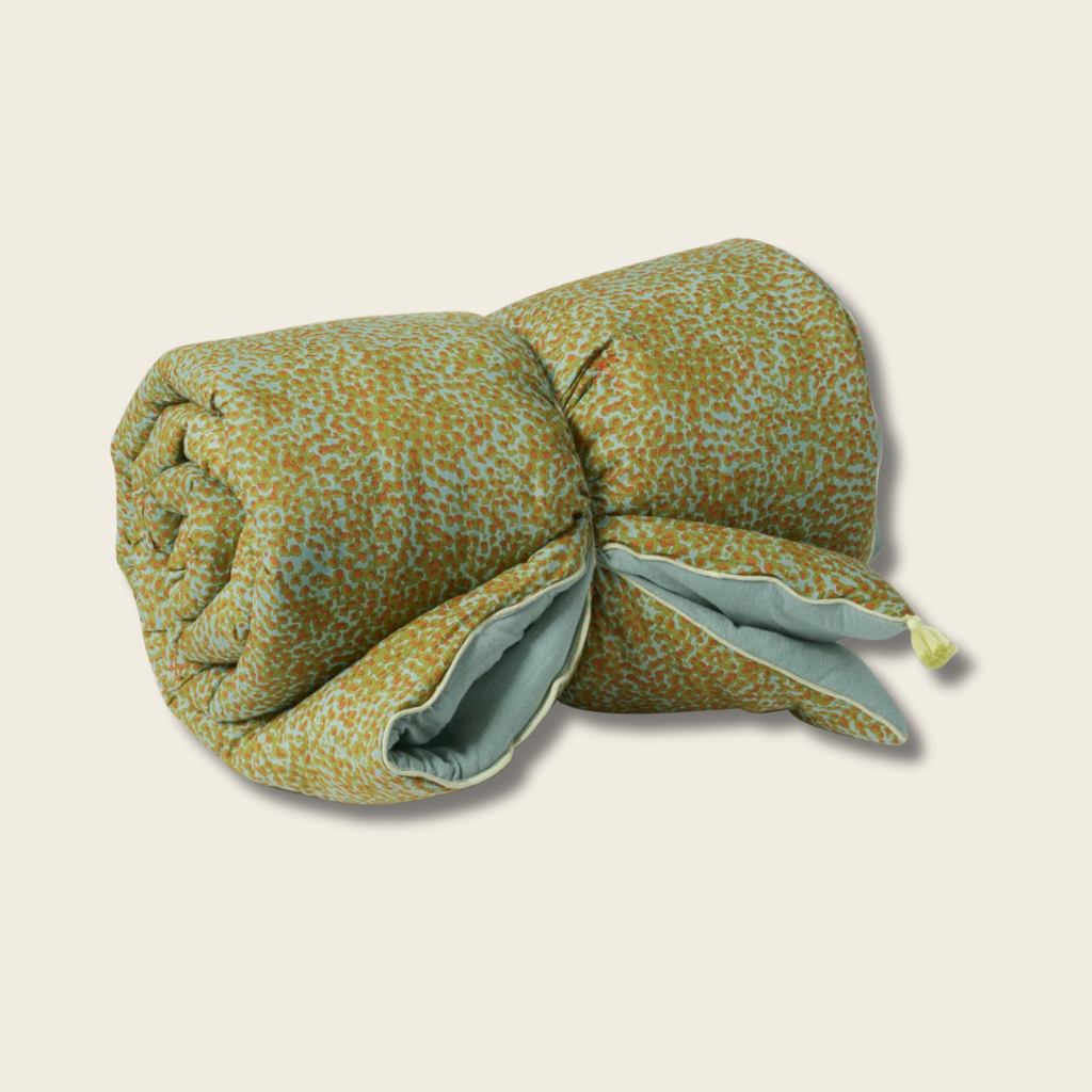 Rolled-up quilt with a floral pattern on a beige background