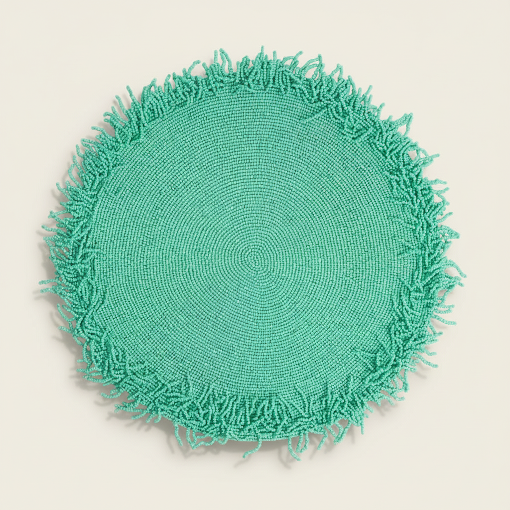 Round green crocheted mat with fringed edge on a light gray background