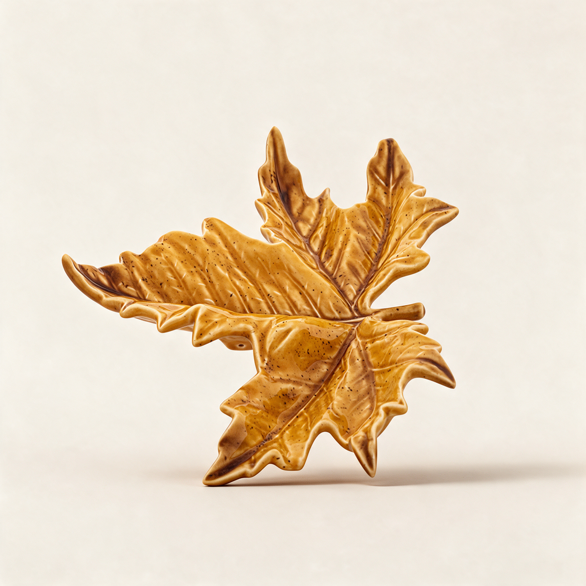 Golden yellow hand-painted earthenware sycamore leaf serving dish from the Gudrun collection