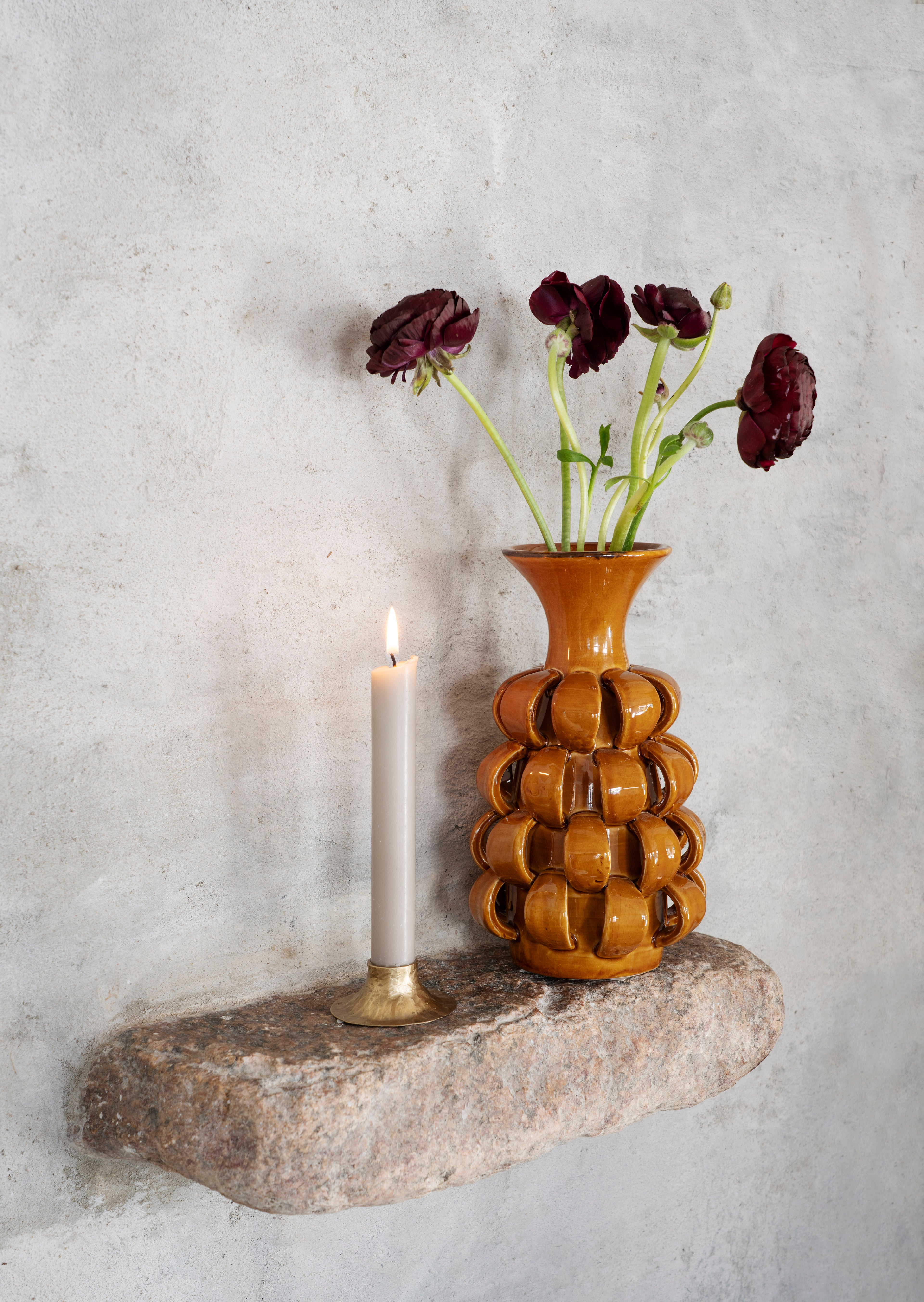 Hand forged brass candle holders grouped with lit dinner candles