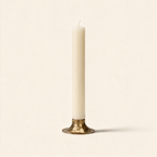 Hand forged iron candle holder with a tulip cup in antique brass on a warm cream background