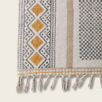 Textile with geometric patterns and fringes on a neutral background