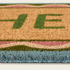 Doormat with 'HOME' text and grass-like texture