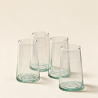 Set of four highball glasses in recycled glass on a cream background