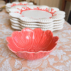 Pink decorative bowl on a floral tablecloth with white plates in the background