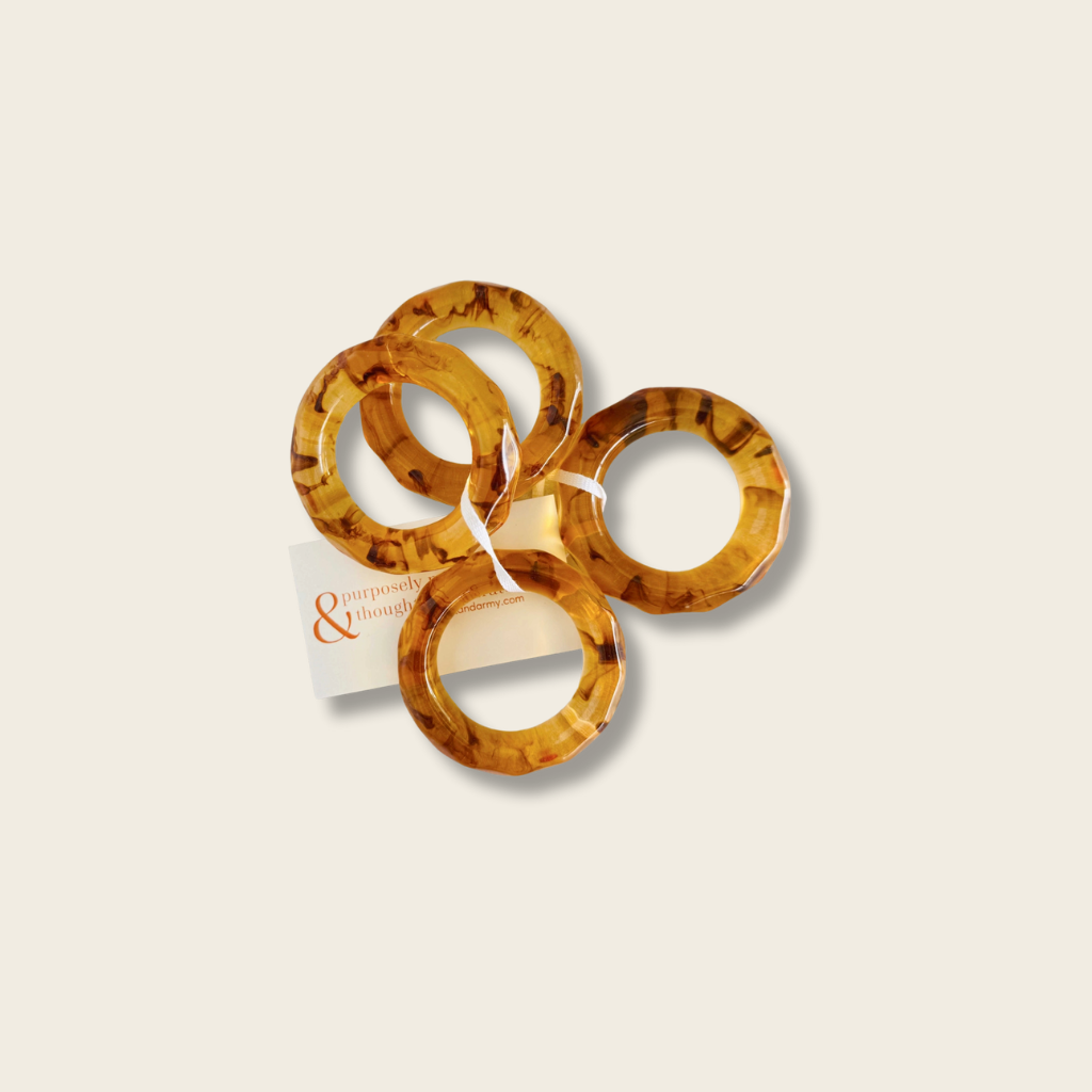set of four tortoise shell acrylic napkin rings tied with a white ribbon