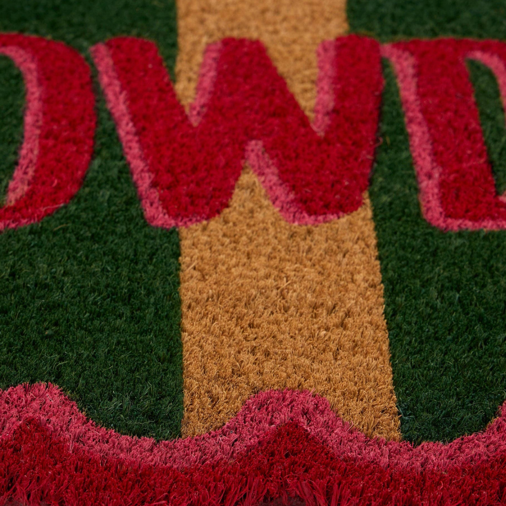 Close up of a coir door mat with the word "W" visible
