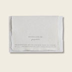 Handmade cotton rag paper card with letter pressed text on the back . 