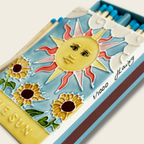 Decorative matchbox with sun and sunflower design on a white background