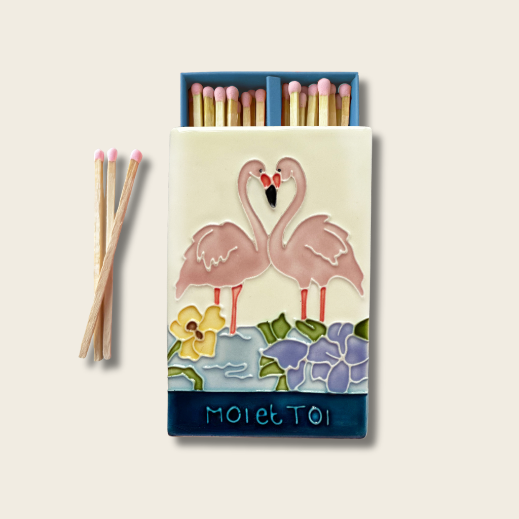 Matches with a decorative box featuring flamingo illustrations on a beige background