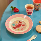 Children's table setting with a plate, cup, and fork on a blue table.
