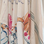 Collection of kitchen towels with various patterns and colours on a neutral background