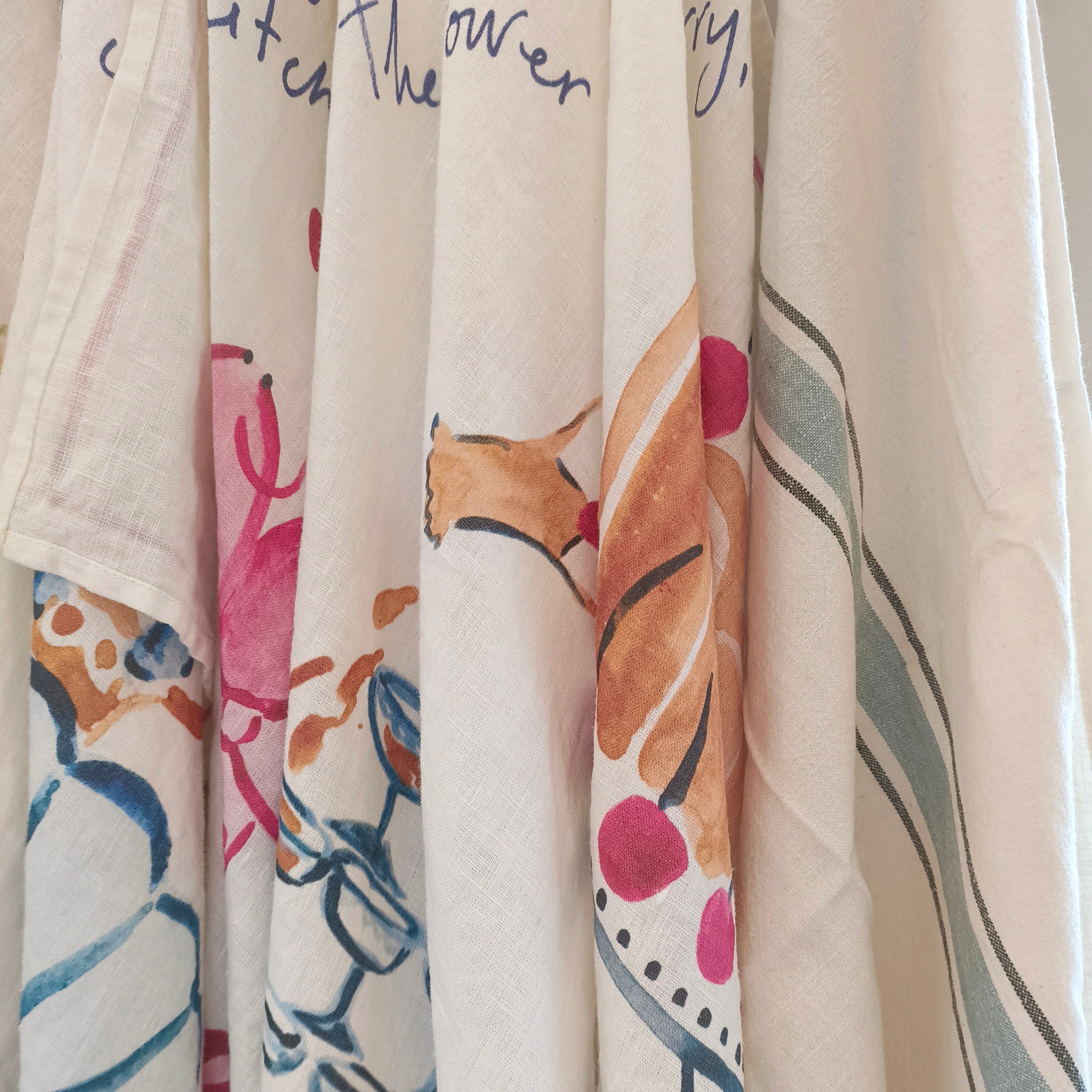 Collection of kitchen towels with various patterns and colours on a neutral background