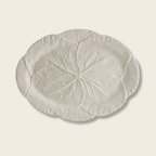 a cream platter with cabbage leaf detail on a beige background