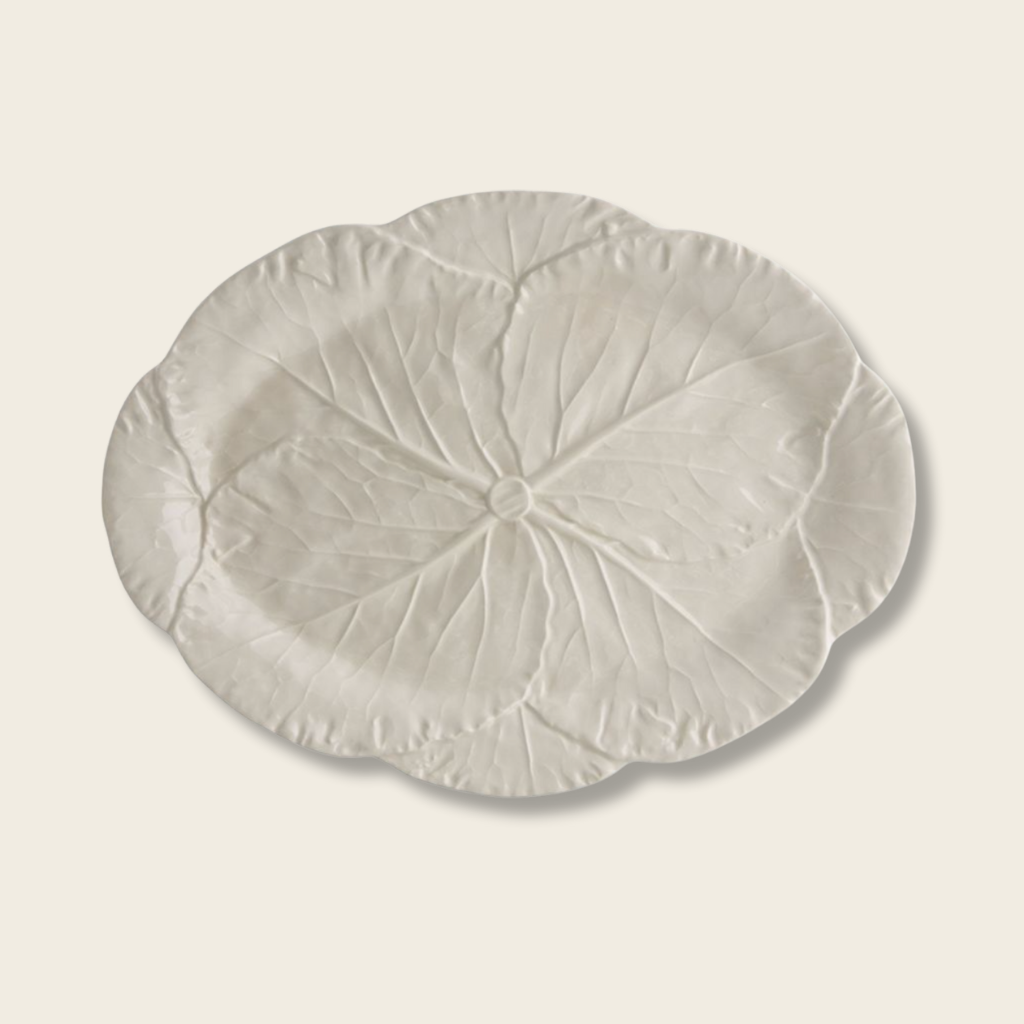 a cream platter with cabbage leaf detail on a beige background