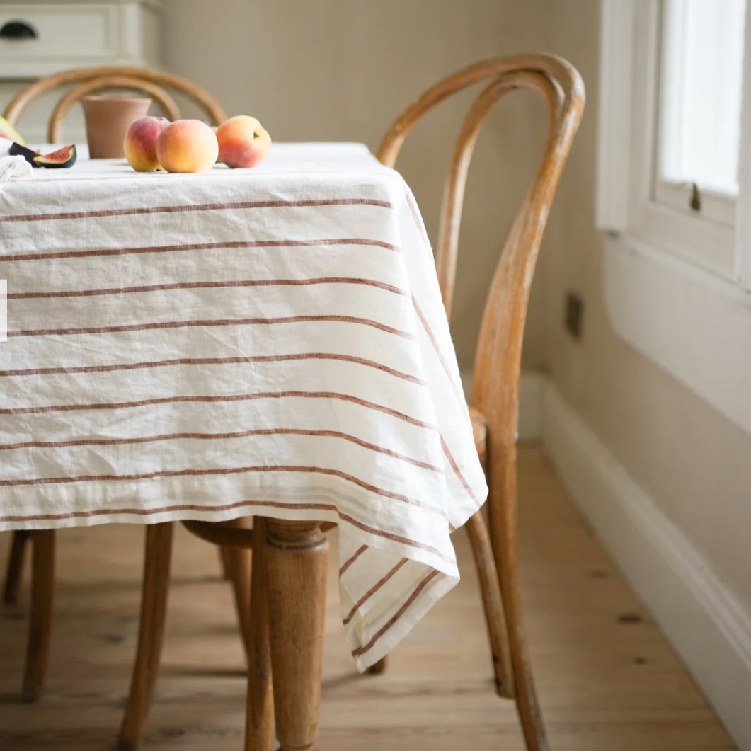 cream linen table cloth with a ginger stripe o a wooden table