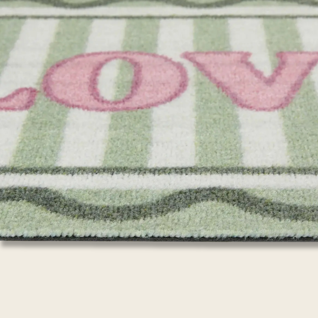 Striped rug with the word 'LOVE' in pink letters on a green and white background