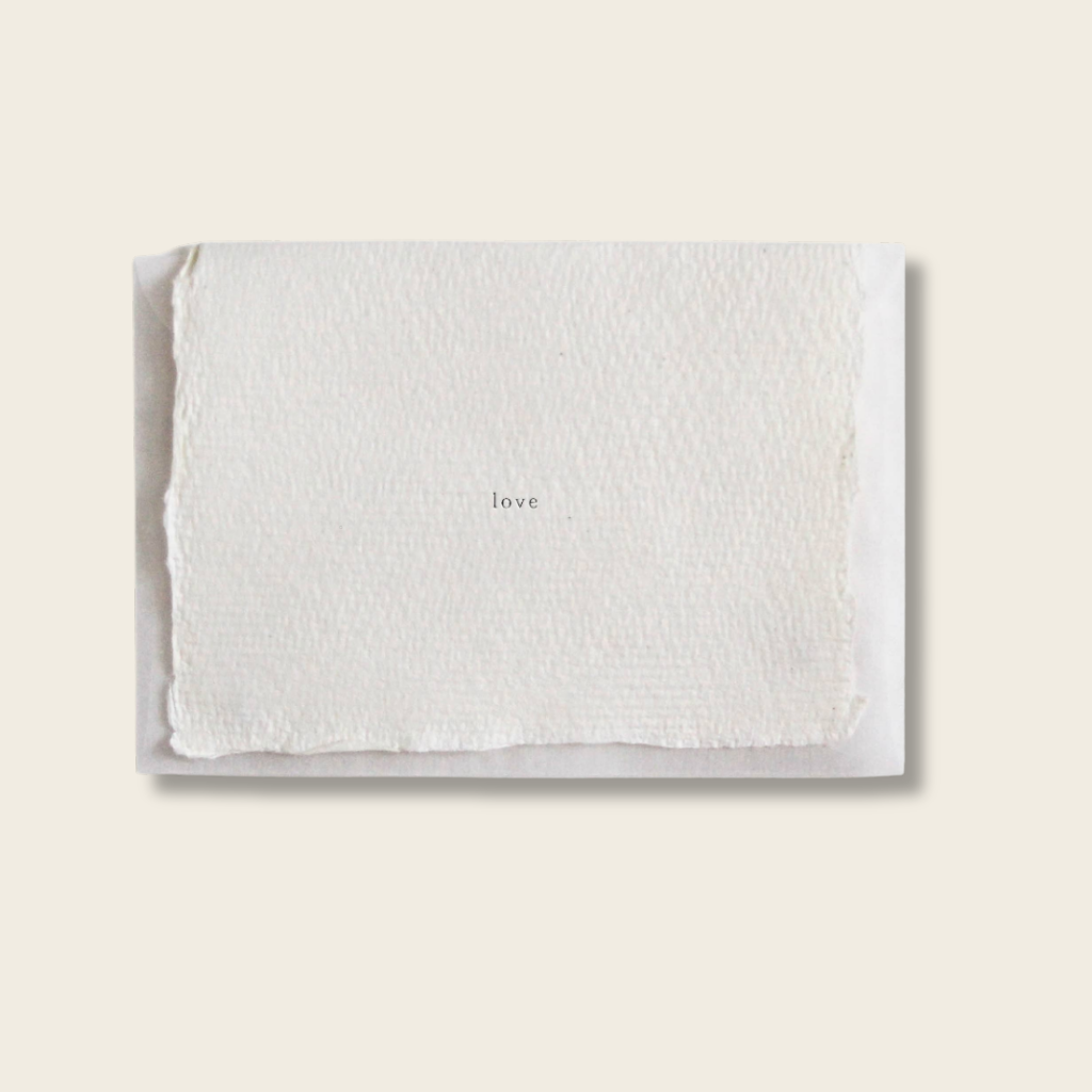 White textured card with 'love' text on a beige background
