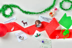 Assorted Christmas-themed items including cards, a crystal ball, and tinsel on a white surface.