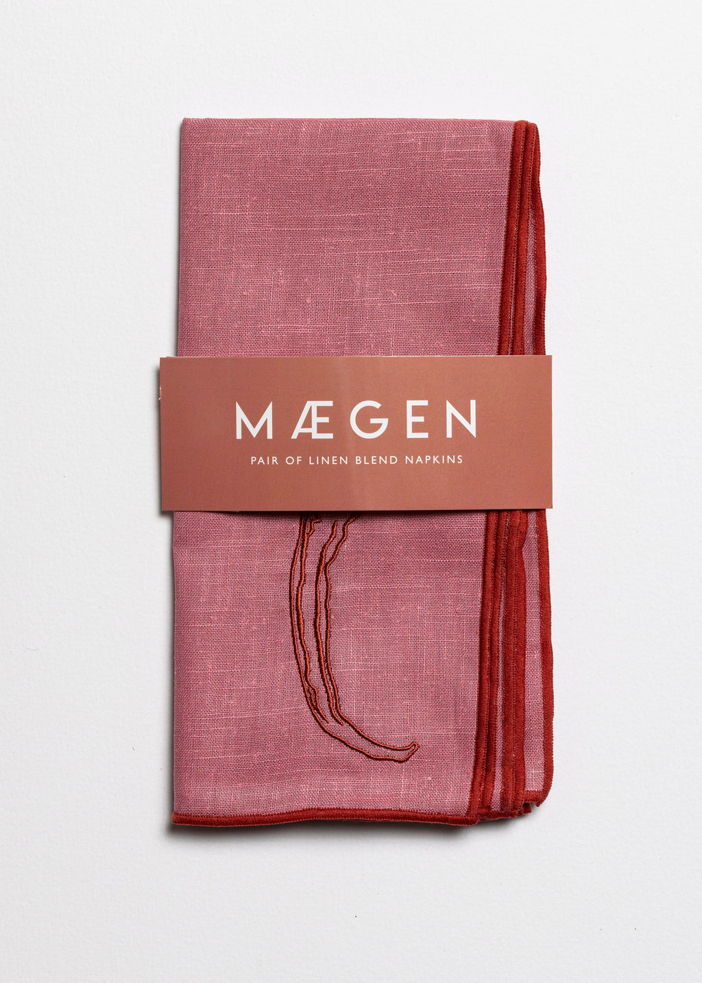 Chilli print linen napkins folded with MÆGEN branded sleeve