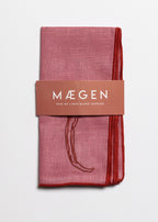 Chilli print linen napkins folded with MÆGEN branded sleeve