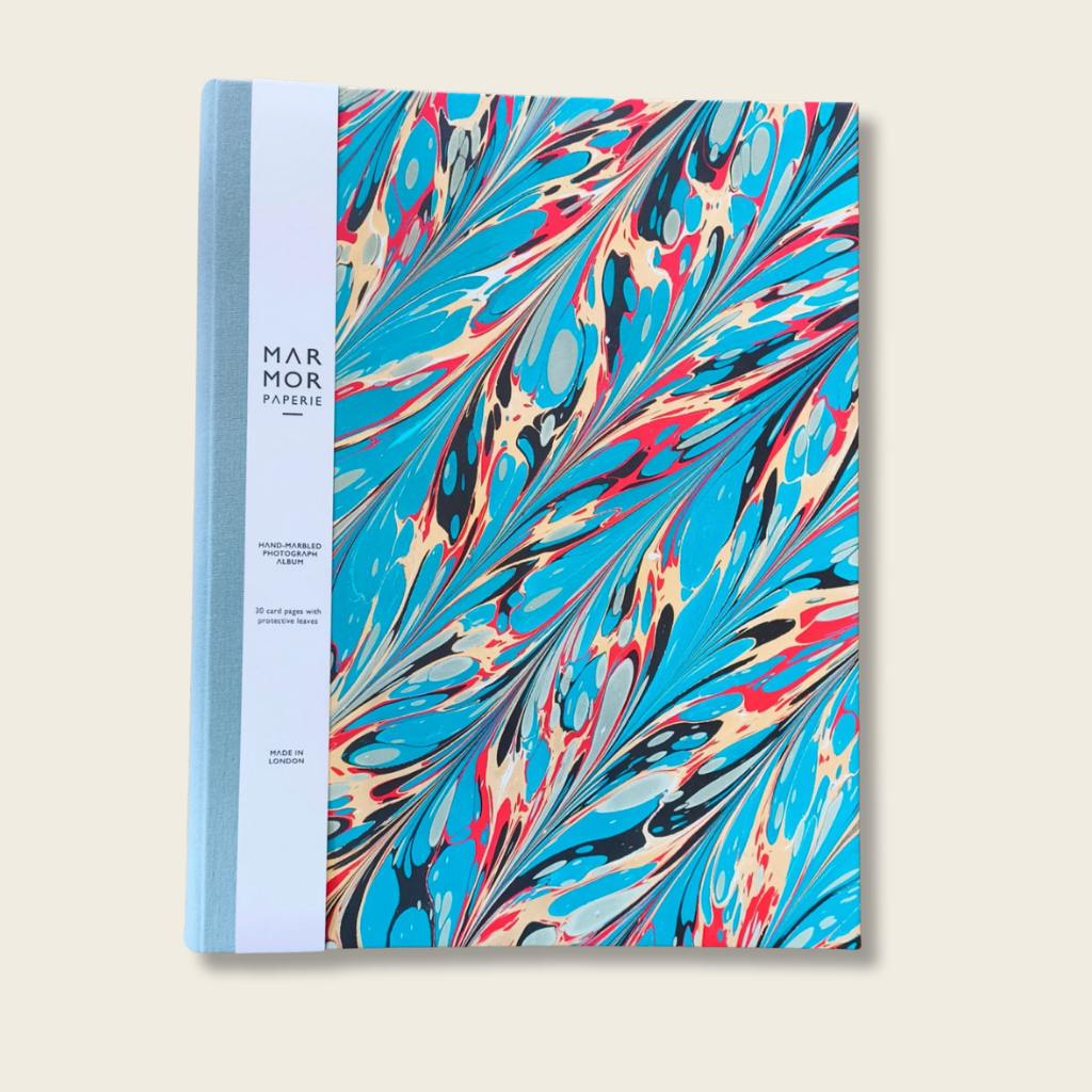 Notebook with colorful marbled design on a beige background