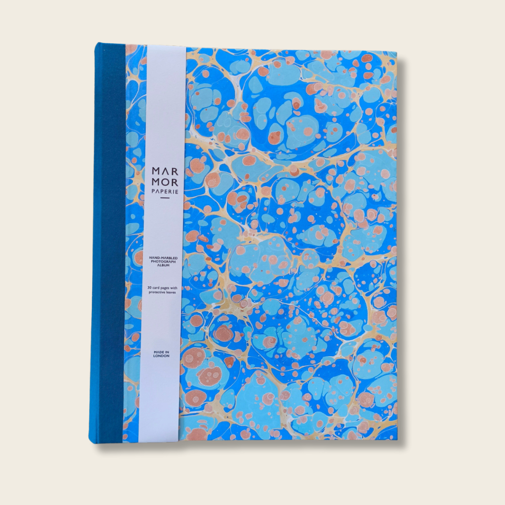Notebook with blue and gold marbled cover on a beige background