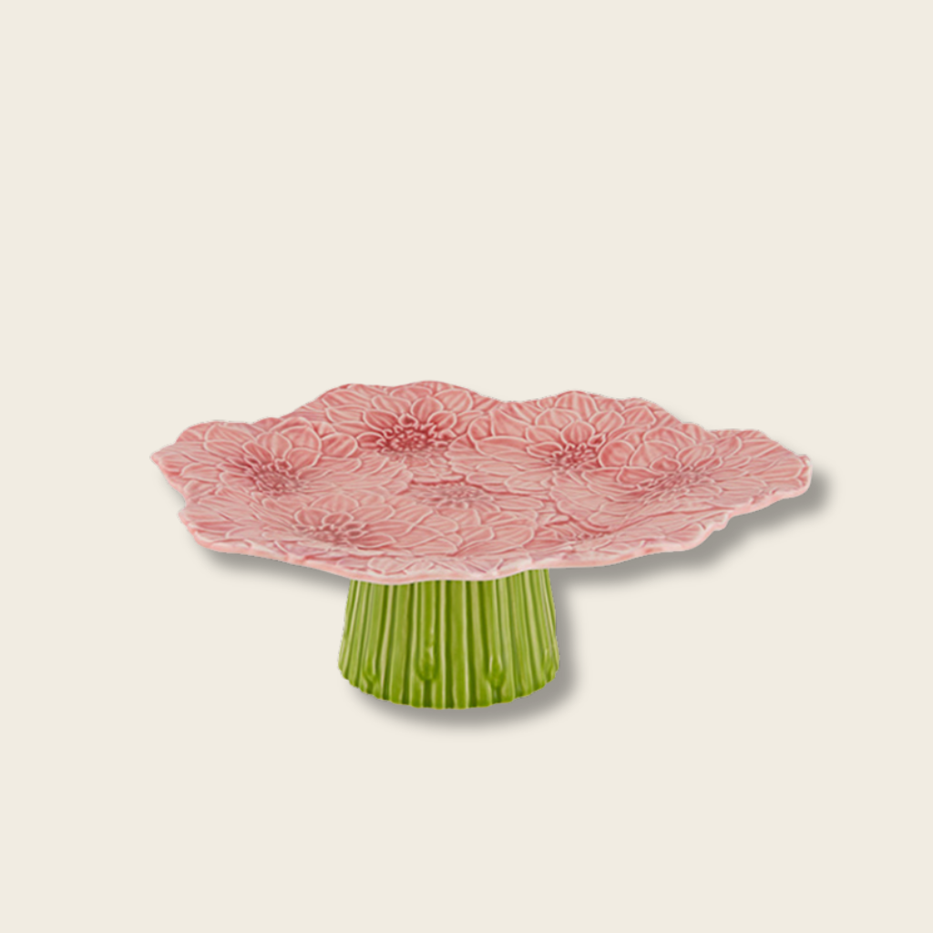 Decorative cake stand with pink floral design and green base on a beige background