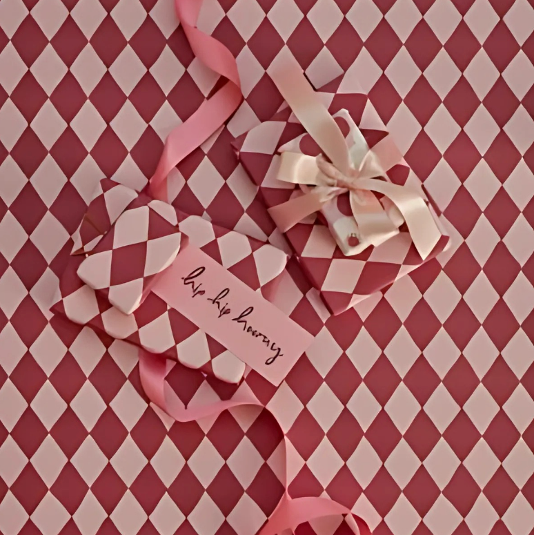 Decorative gift box with ribbons and a tag on a red and white checkered background
