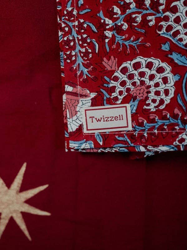 Merlot and gold star tablecloth laid across a dining table