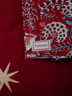 Merlot and gold star tablecloth laid across a dining table