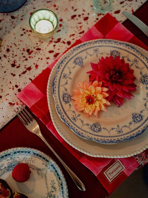 Merlot and gold star cotton tablecloth draped over a table edge
