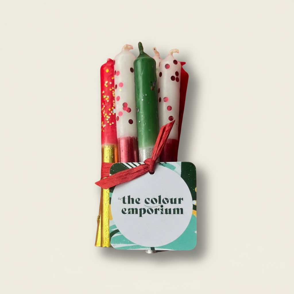 Set of colorful candles in a holder with 'the colour emporium' label on a white background