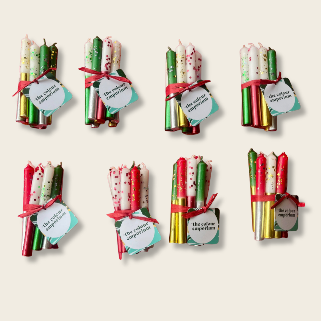 Set of wrapped candles with colorful patterns and ribbons on a beige background